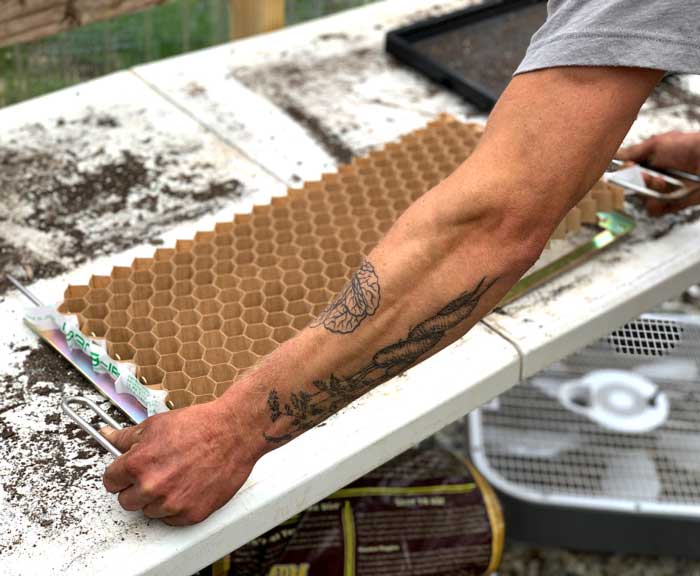 Chris setting up a Paper Pot transplanter seed flat/cells.